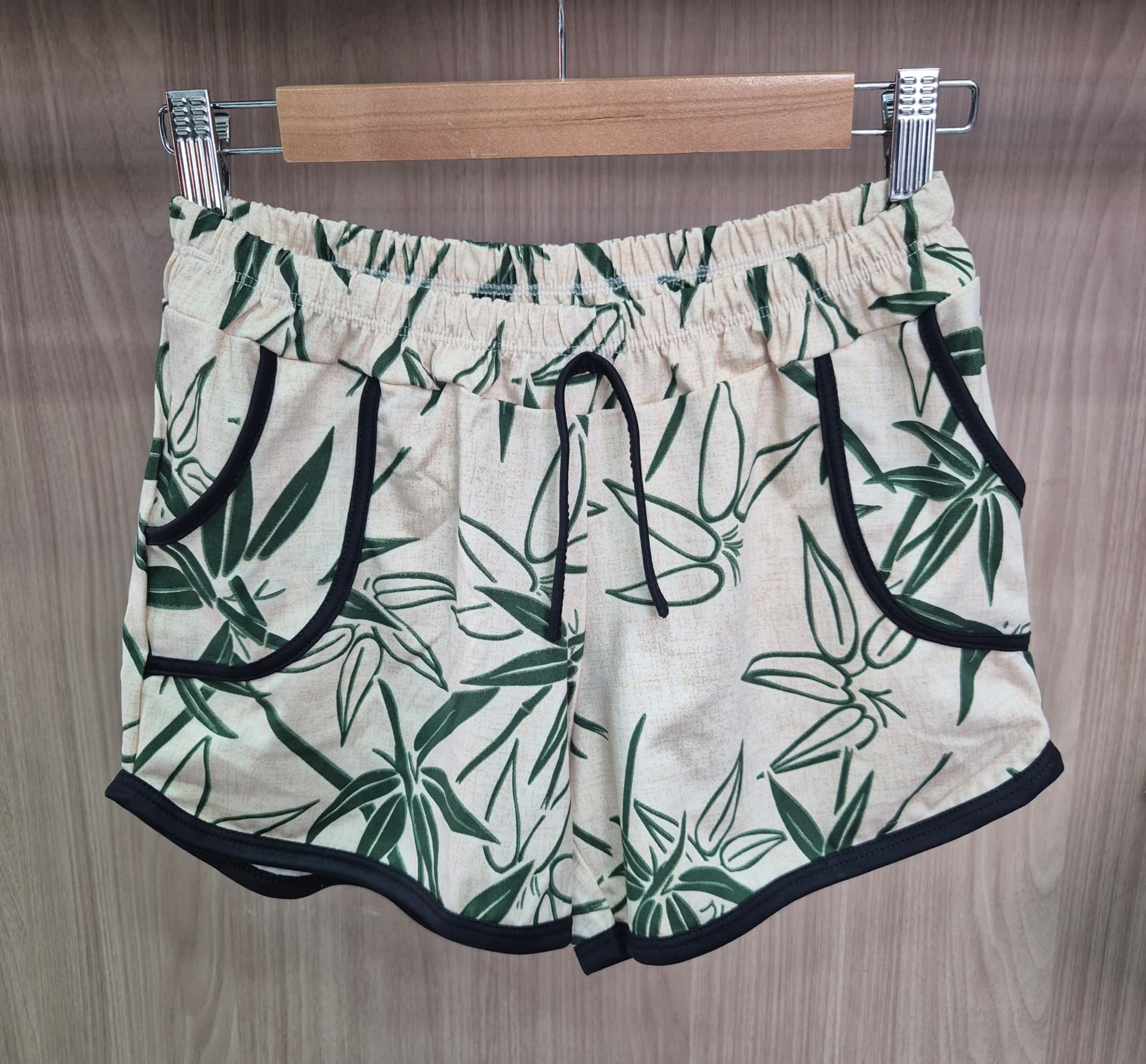Short feminino com estampa de folhagens verdes em fundo claro