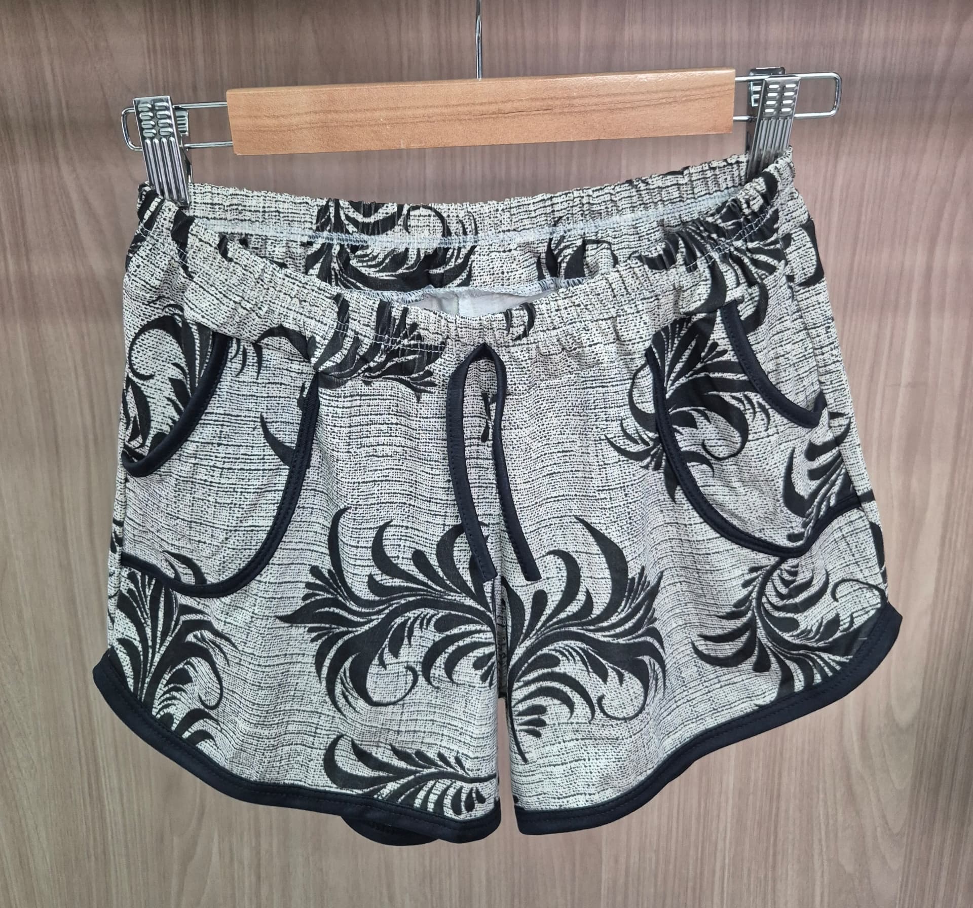 Short feminino com estampa de folhagens pretas em fundo claro