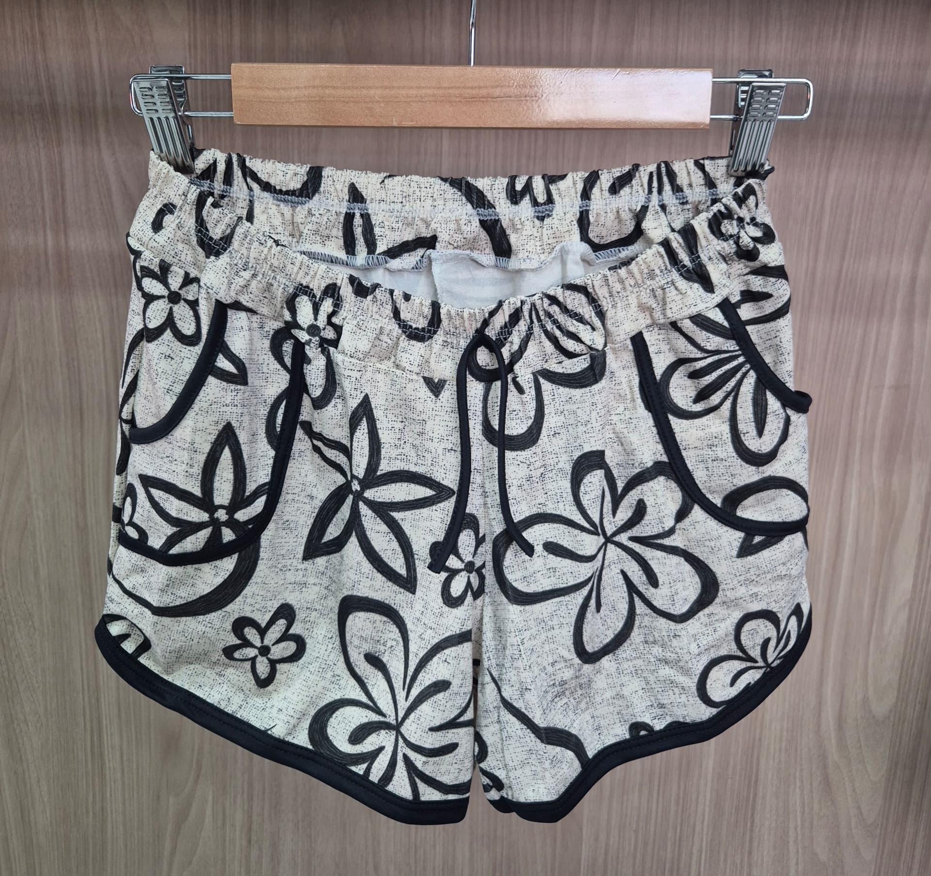 Short feminino com estampa floral preta em fundo claro